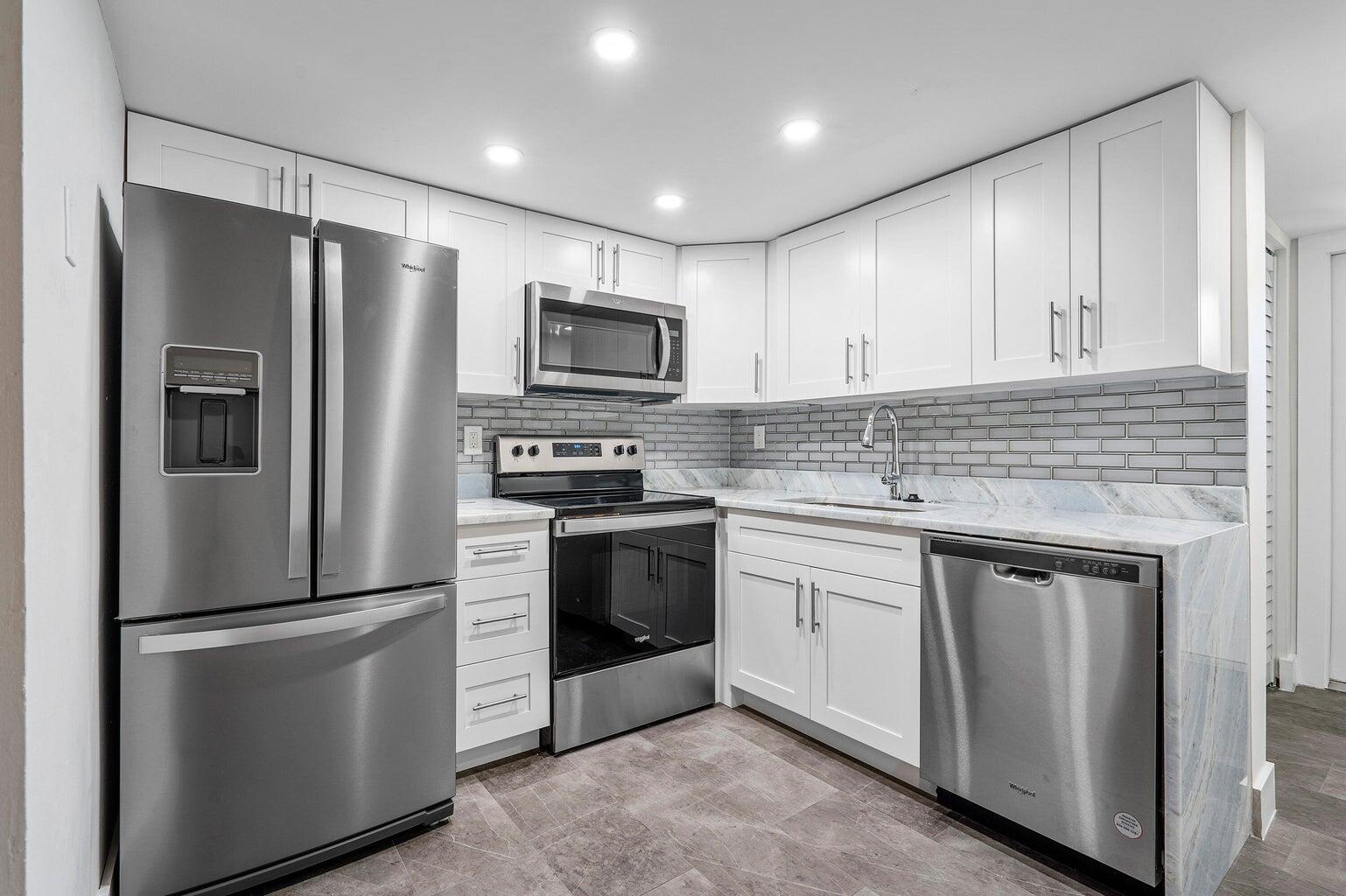 a kitchen with stainless steel appliances cabinets a refrigerator and a stove top oven
