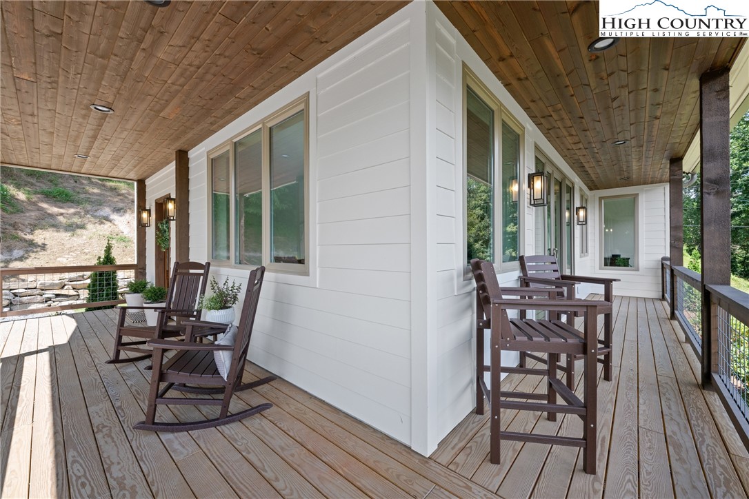 2181 Broadstone Road Banner Elk, NC 28604 - Photo 6 of 38 a view of a patio with table and chairs and wooden floor