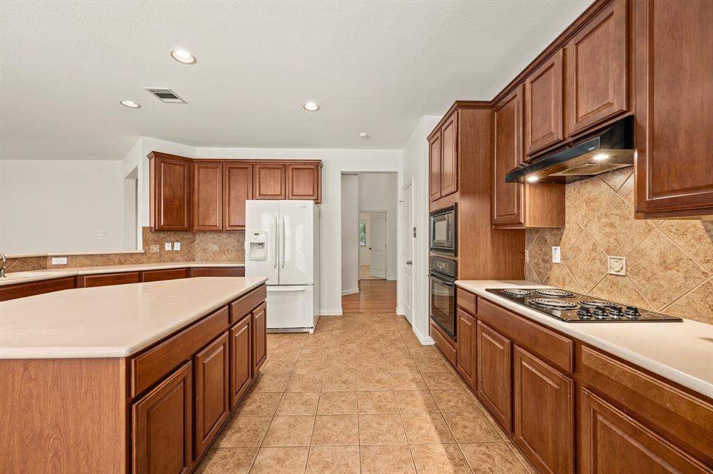 808 Briar Ridge Drive Keller, TX 76248 - Photo 15 of 40 Spacious kitchen featuring warm wood cabinetry, light-toned countertops, and a full tile backsplash