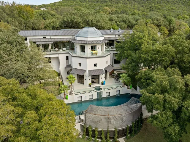 an aerial view of a house with swimming pool and garden