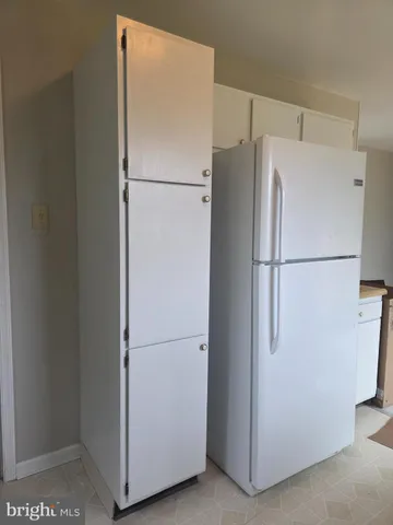 a white refrigerator freezer and a refrigerator in a kitchen