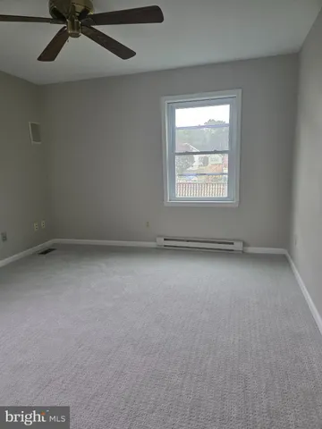 an empty room with a window and a fan