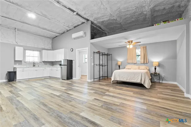 a room with a bed and a view of kitchen