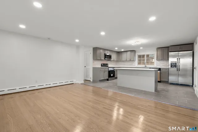 a view of kitchen with stainless steel appliances granite countertop a stove top oven a sink and dishwasher