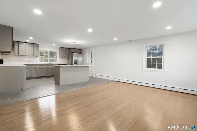 a large kitchen with stainless steel appliances granite countertop a refrigerator and a stove top oven