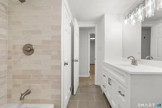 a bathroom with a double vanity sink a mirror and a shower