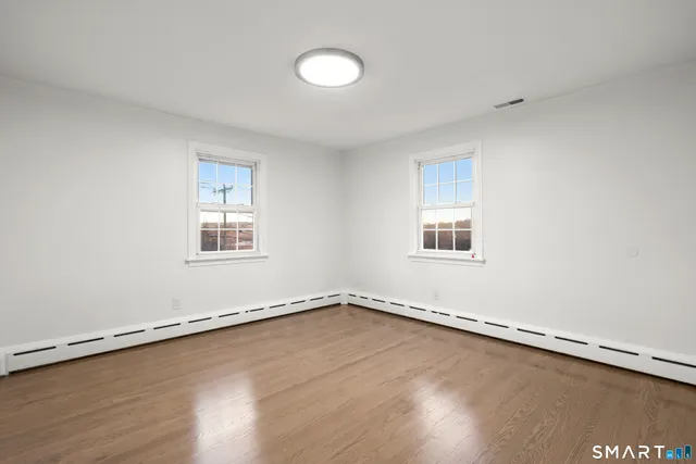a view of a room with wooden floor and window