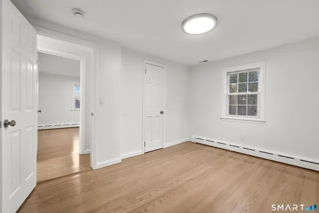 a view of a room with wooden floor and window