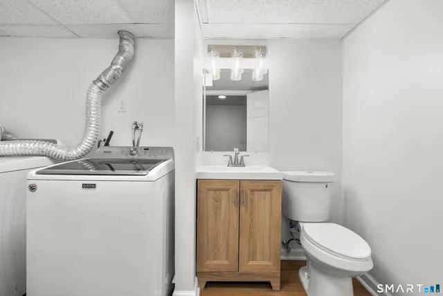 a bathroom with a toilet a sink and mirror