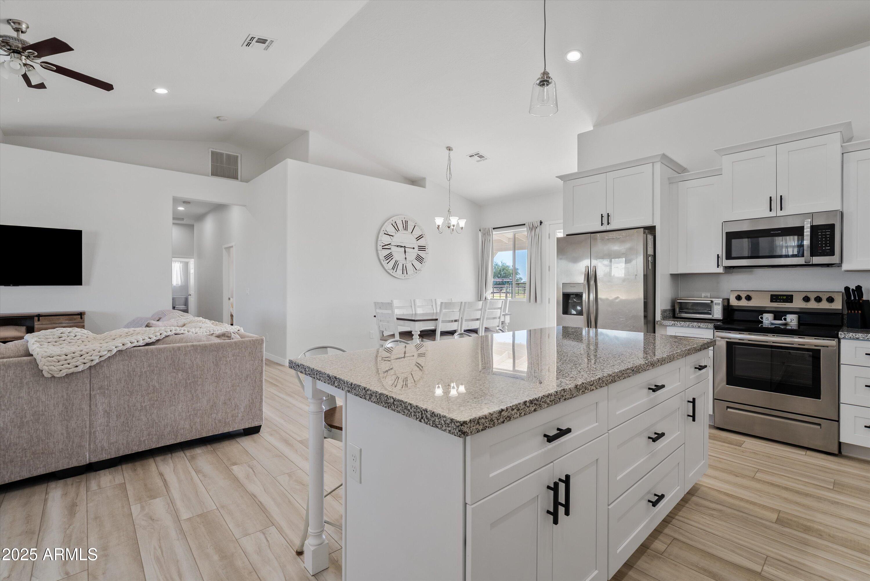 10473 East Dixie Road Florence, AZ 85132 - Photo 10 of 42 a kitchen with stainless steel appliances granite countertop a lot of counter space and wooden floors