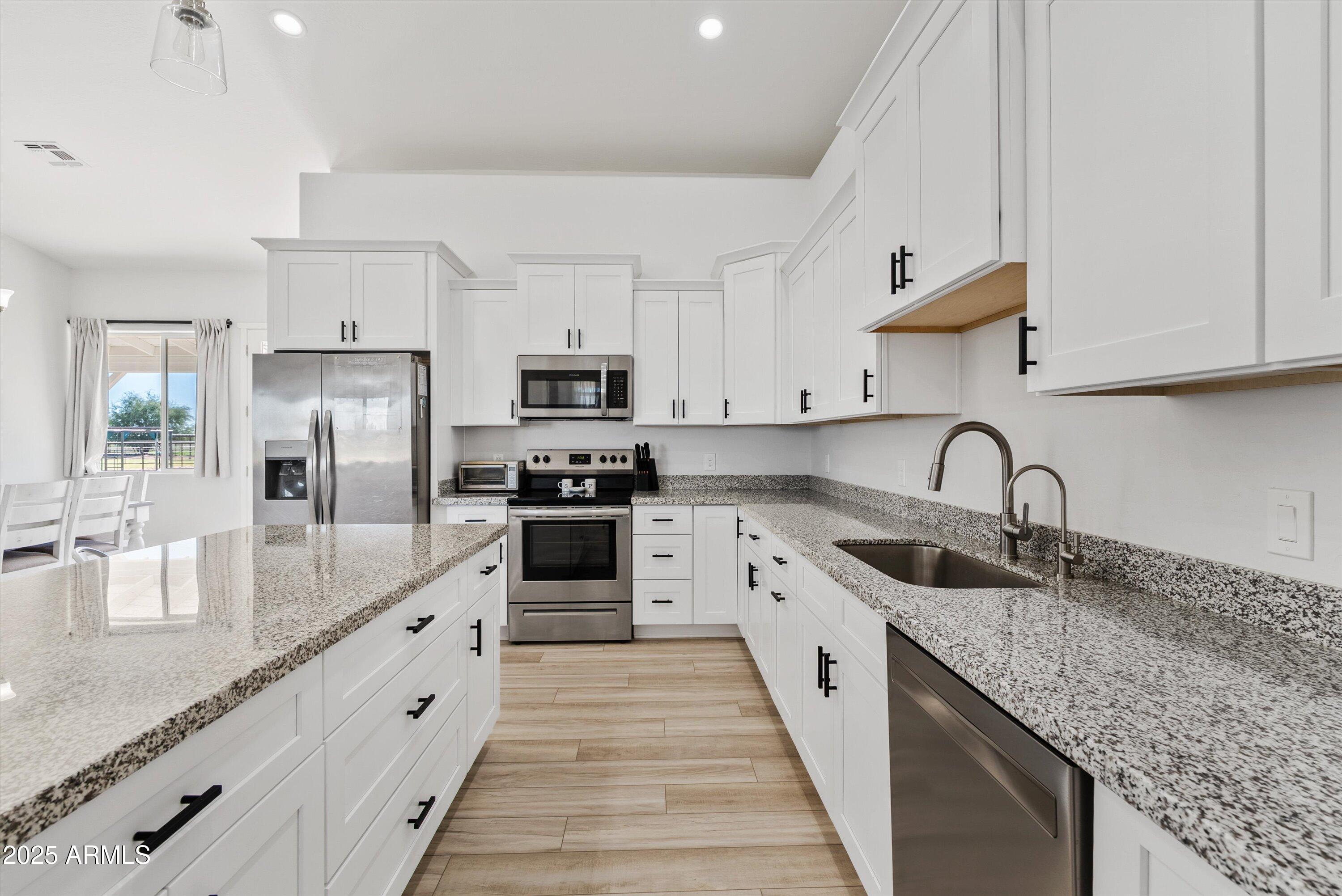 10473 East Dixie Road Florence, AZ 85132 - Photo 13 of 42 a kitchen with granite countertop a sink stove and refrigerator