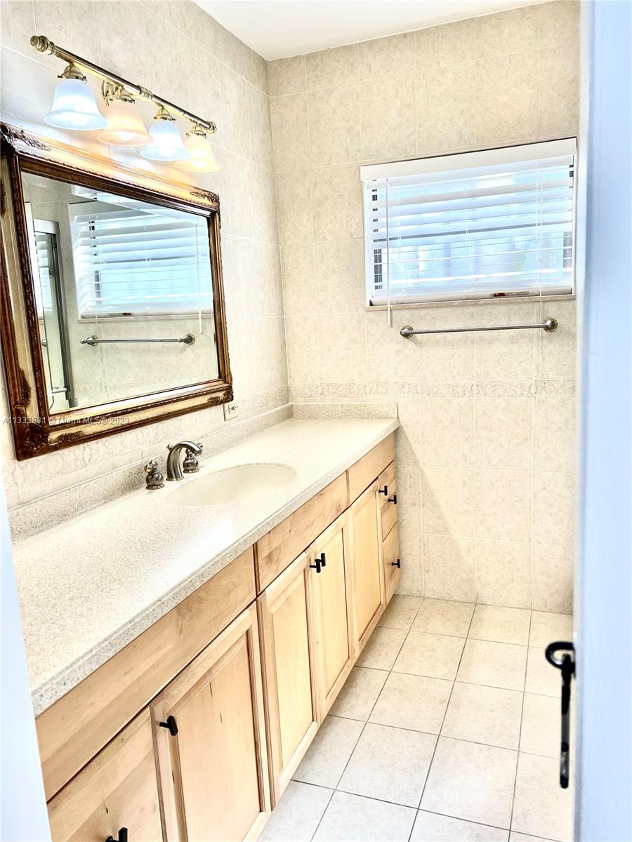 8600 Southwest 33rd Terrace Miami, FL 33155 - Photo 7 of 14 a bathroom with a granite countertop sink a mirror and a bathtub