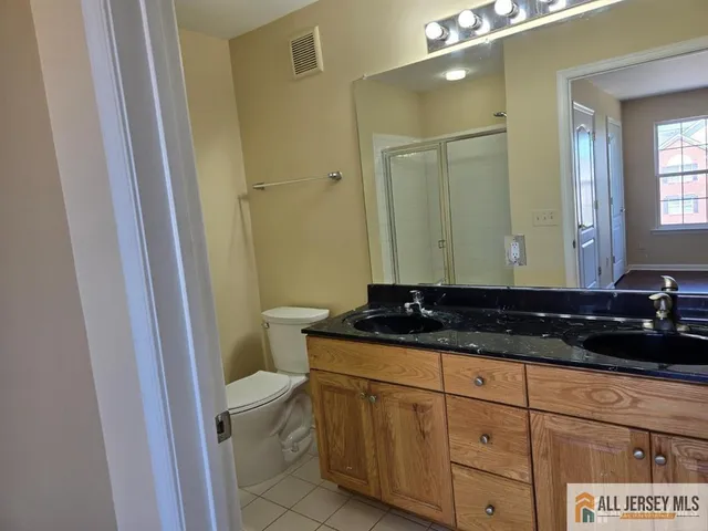 a bathroom with a granite countertop sink a toilet and a mirror