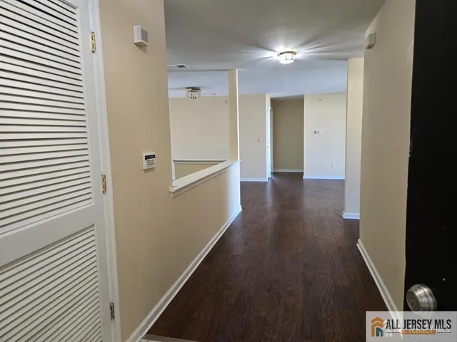 a view of hallway with stairs and wooden floor