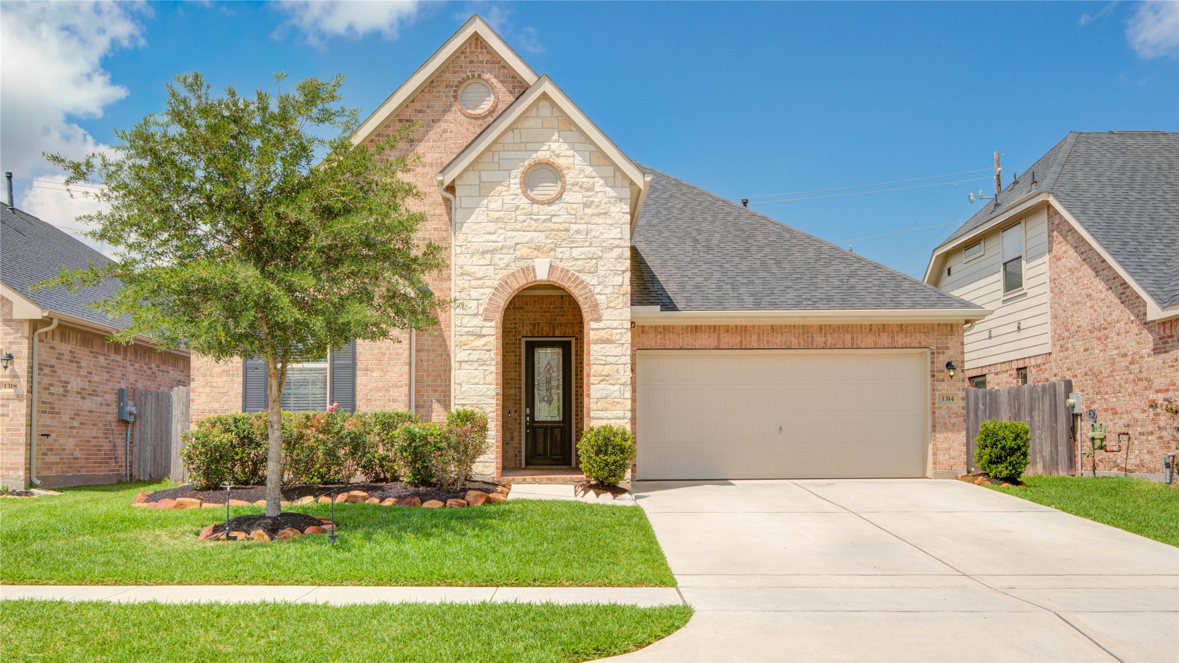 1314 Orchard Ridge Lane Tomball, TX 77375 - Photo 3 of 35 Inviting brick and stone elevation showcases timeless curb appeal with a welcoming arched entry and manicured landscaping.