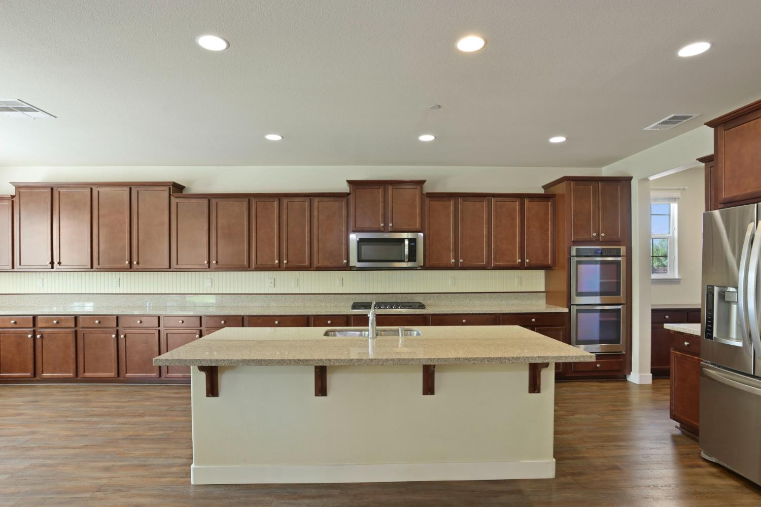 2364 Inyo Place Manteca, CA 95337 - Photo 26 of 69 a view of a kitchen with stainless steel appliances granite countertop a stove a sink and a microwave