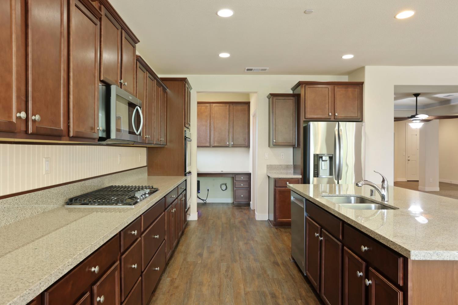 2364 Inyo Place Manteca, CA 95337 - Photo 28 of 69 a kitchen with stainless steel appliances granite countertop a stove a sink dishwasher and a refrigerator with wooden cabinets