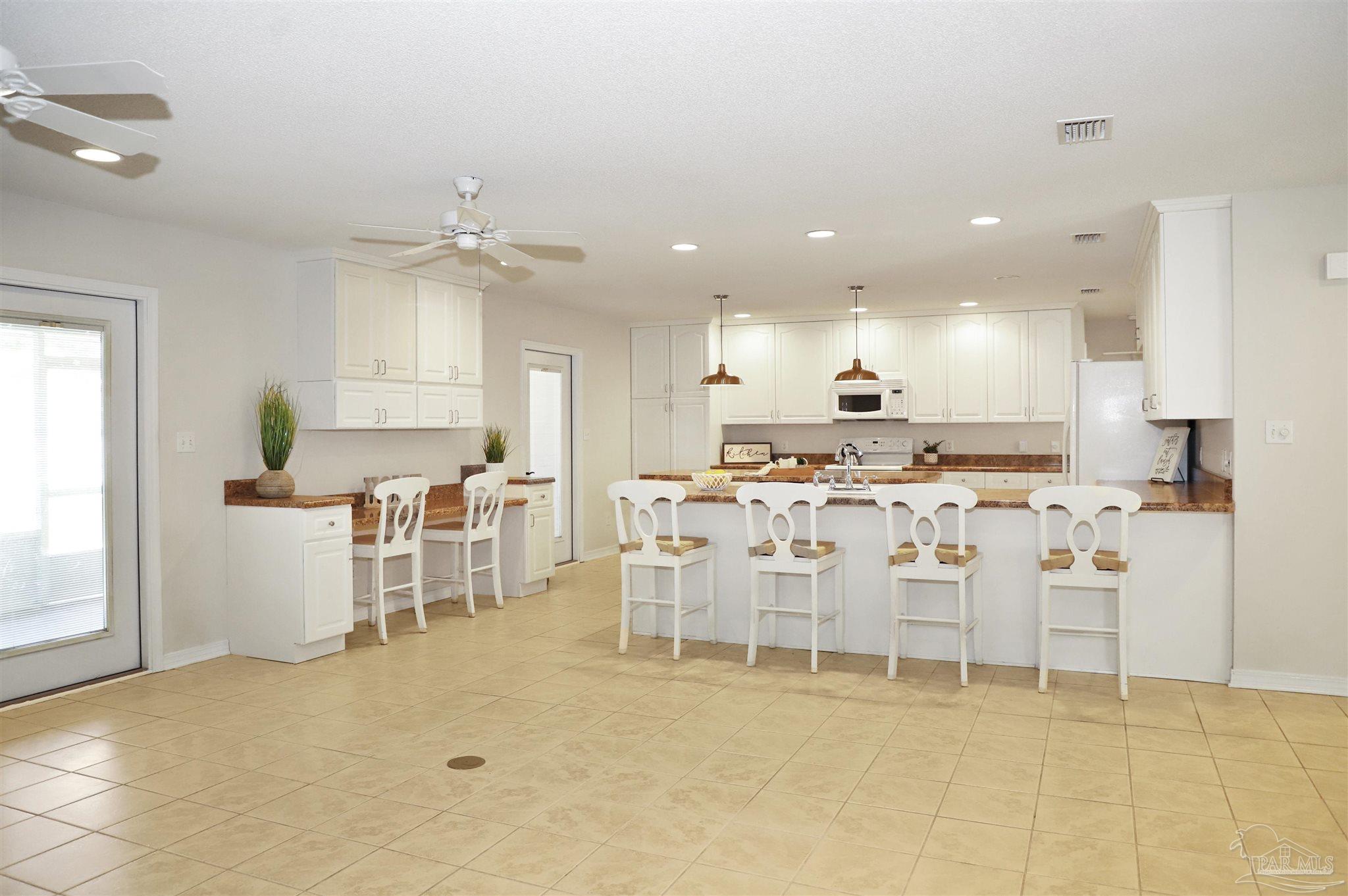 4454 Lyons Place Holt, FL 32564 - Photo 14 of 53 a large kitchen with lots of counter space and chairs