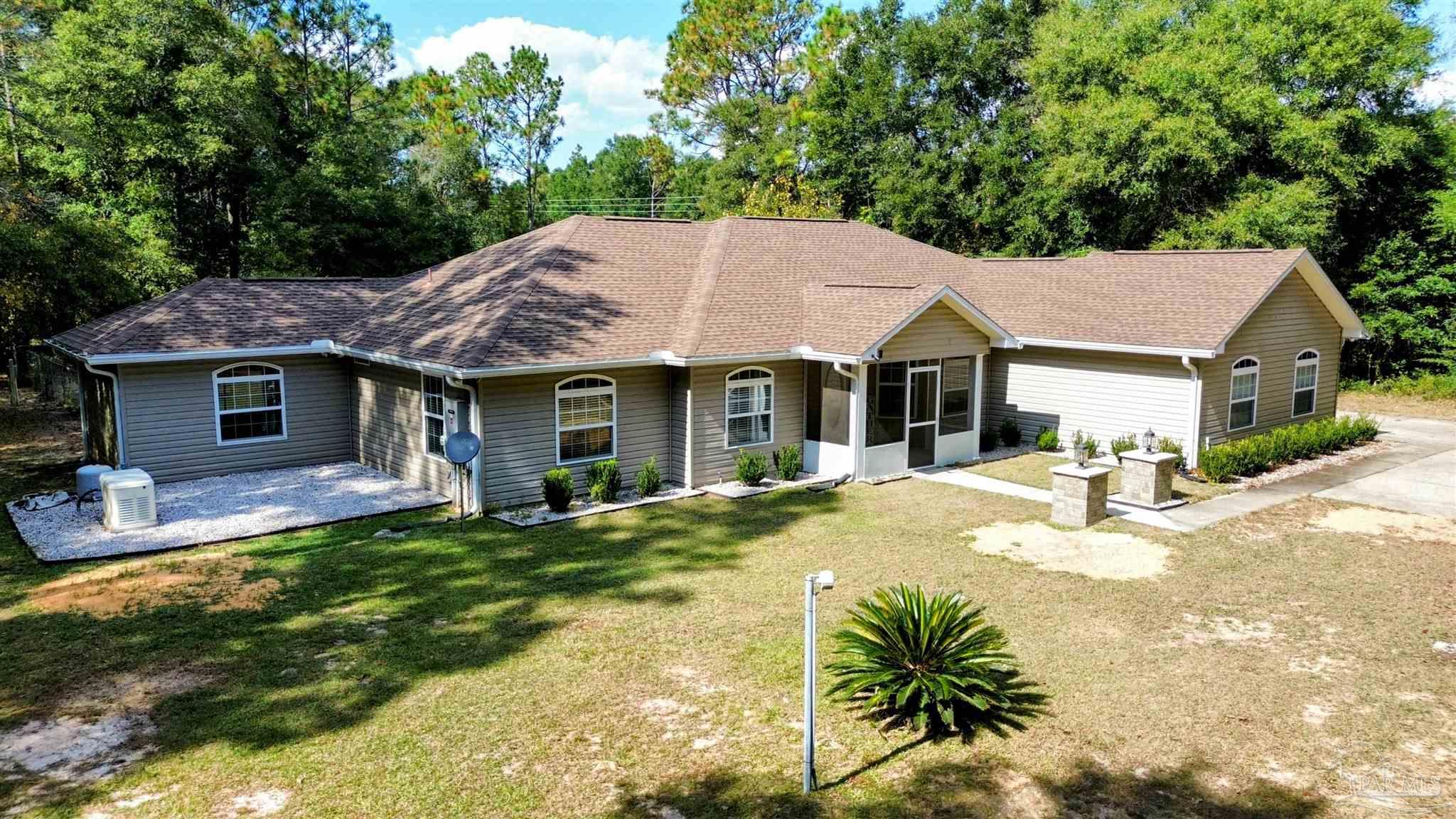4454 Lyons Place Holt, FL 32564 - Photo 2 of 53 a view of a house with a yard patio and fire pit