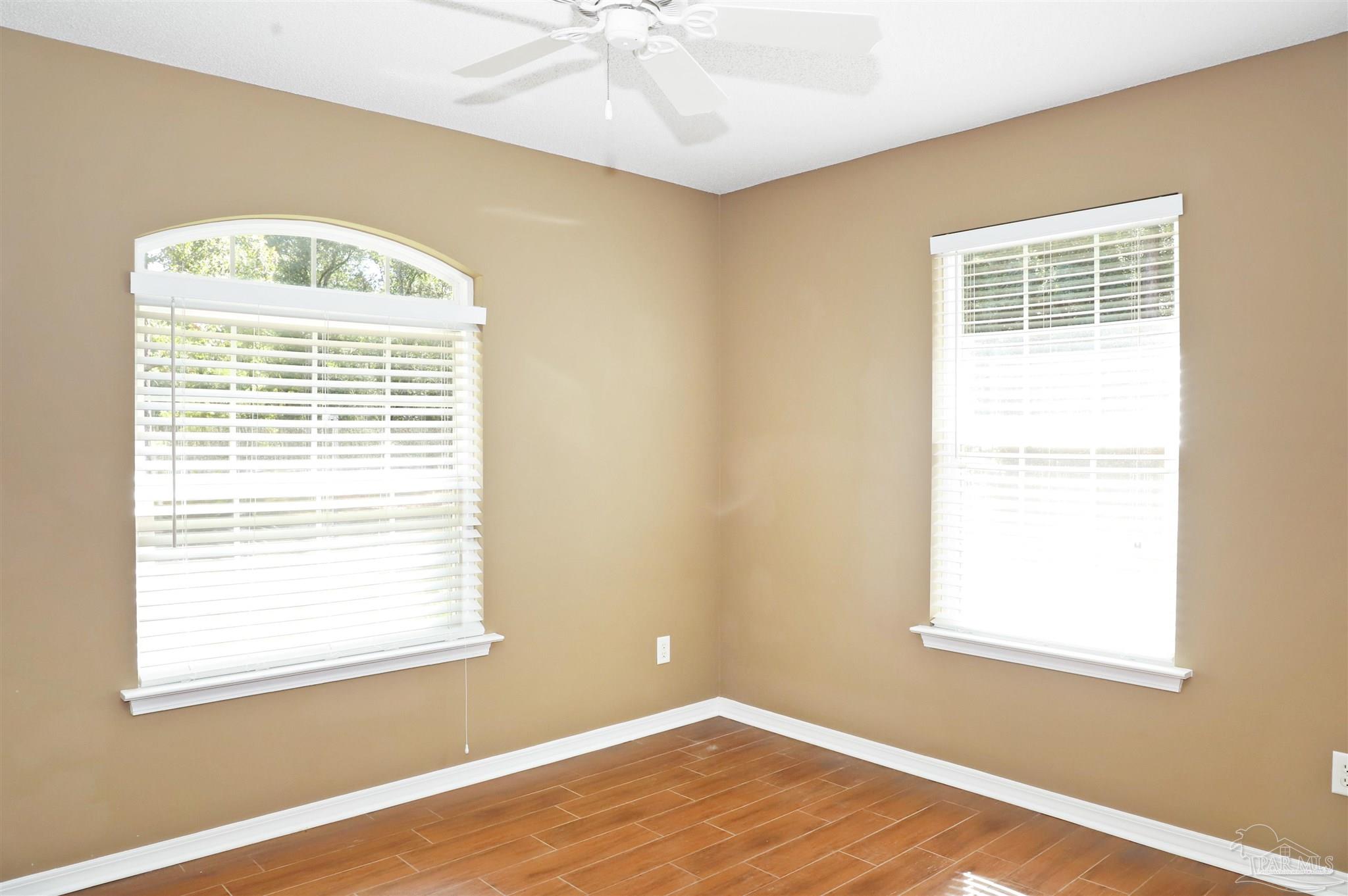 4454 Lyons Place Holt, FL 32564 - Photo 34 of 53 a view of an empty room with wooden floor and a window