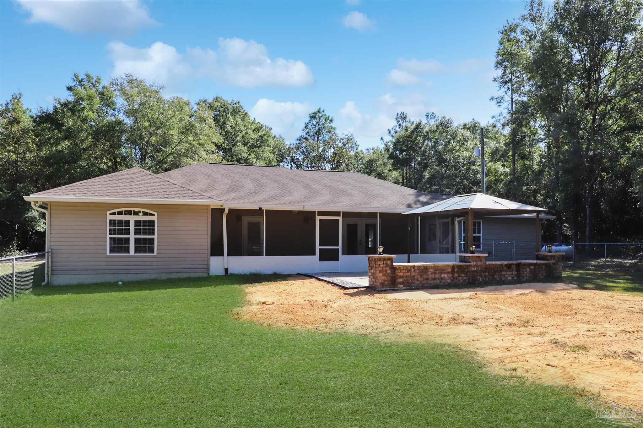 4454 Lyons Place Holt, FL 32564 - Photo 41 of 53 a front view of a house with a yard and trees