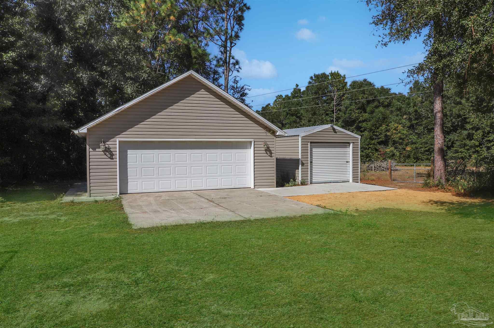 4454 Lyons Place Holt, FL 32564 - Photo 42 of 53 a front view of a house with a yard and garage