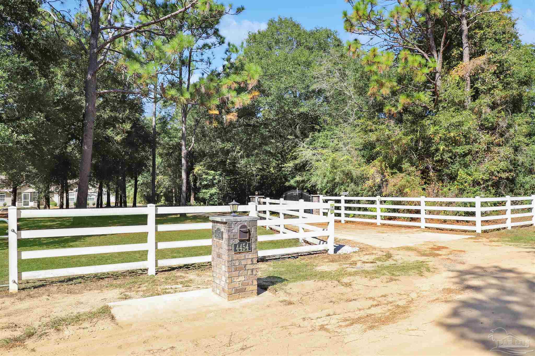 4454 Lyons Place Holt, FL 32564 - Photo 46 of 53 a view of a swimming pool with an outdoor seating and a forest