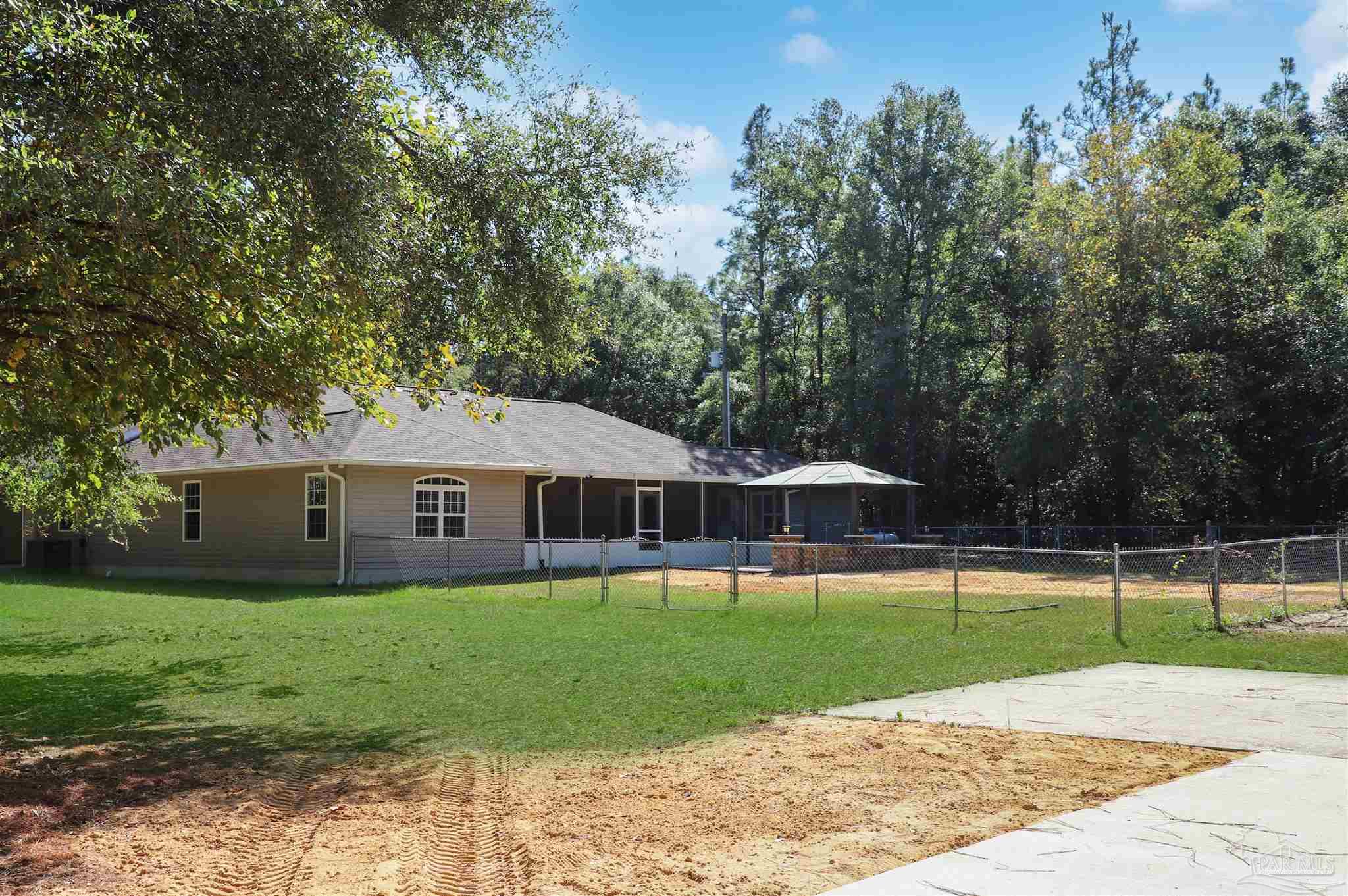 4454 Lyons Place Holt, FL 32564 - Photo 50 of 53 a view of a house with a yard and trees