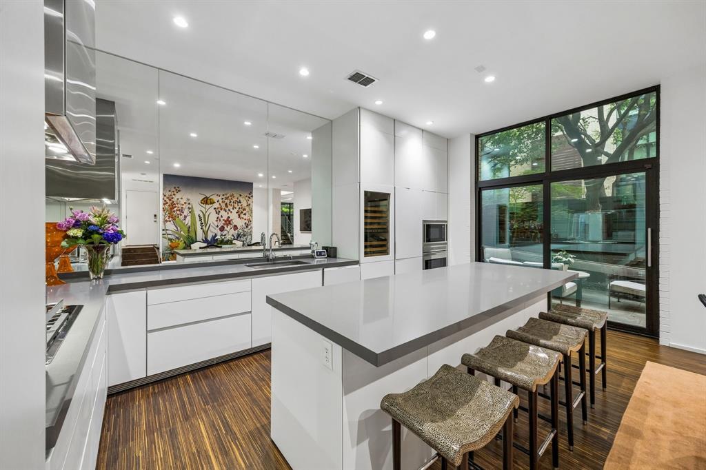 4321 Travis Street Dallas, TX 75205 - Photo 11 of 40 a view of kitchen island with stainless steel appliances furniture refrigerator and wooden floor