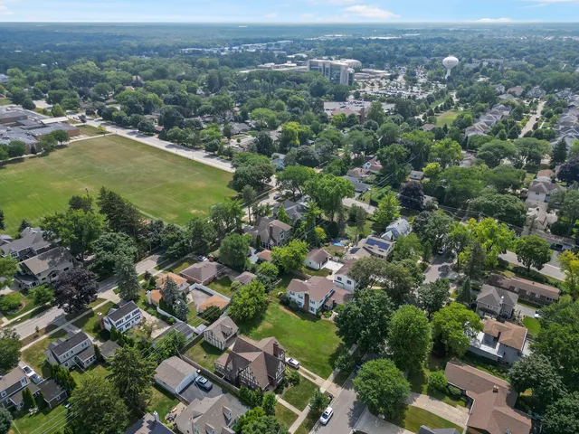 an aerial view of residential houses with outdoor space and trees