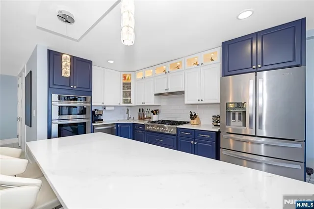 a kitchen with a refrigerator and a stove top oven