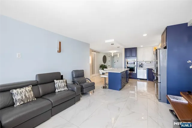 a living room with furniture and a refrigerator