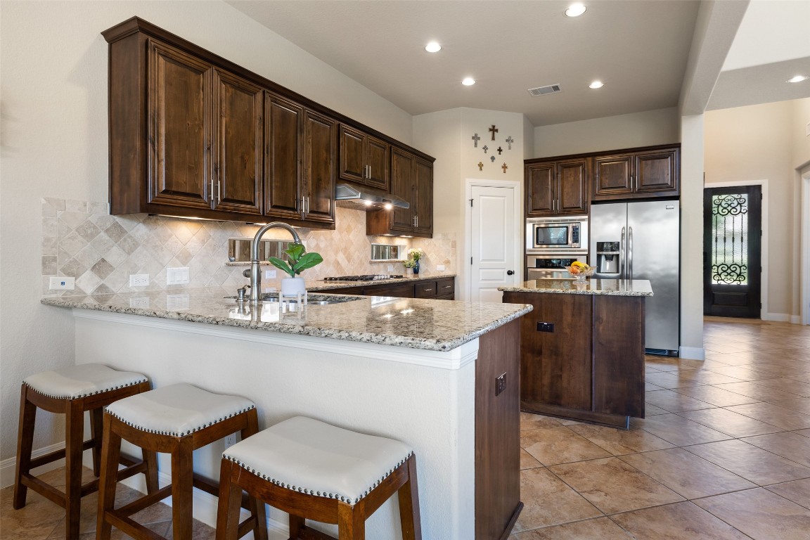 8709 Fescue Lane Austin, TX 78738 - Photo 10 of 36 a kitchen with stainless steel appliances granite countertop a sink counter space and cabinets