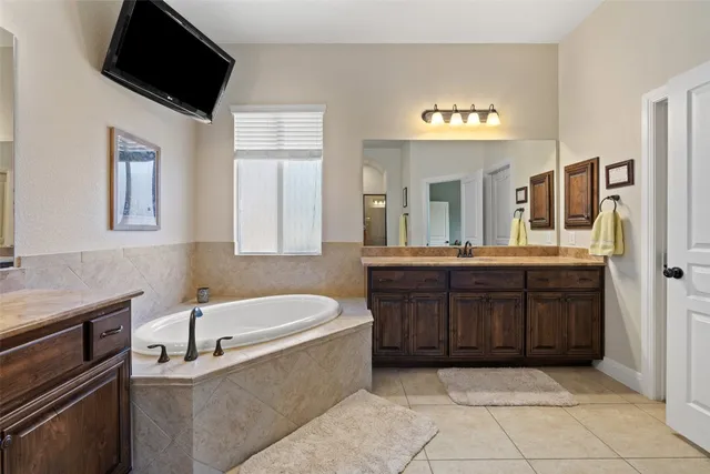 a bathroom with a tub sink a mirror and a shower