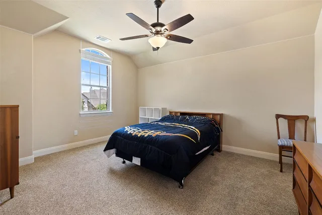 a bedroom with a bed and a ceiling fan