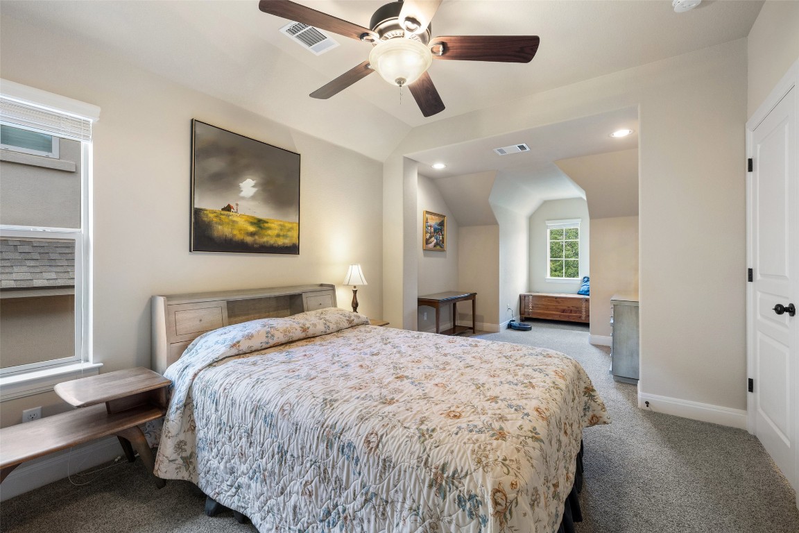 8709 Fescue Lane Austin, TX 78738 - Photo 22 of 36 a spacious bedroom with a bed and a chandelier