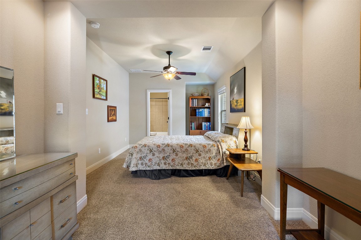 8709 Fescue Lane Austin, TX 78738 - Photo 23 of 36 a spacious bedroom with a bed and a dresser