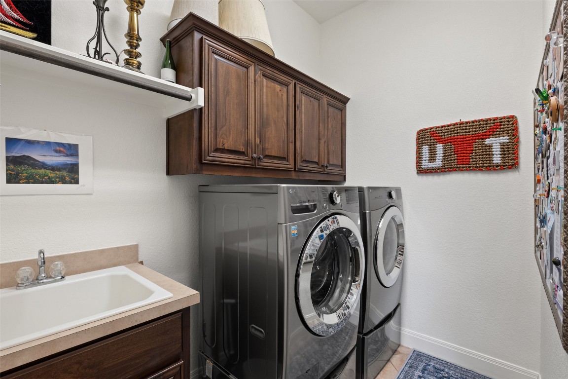 8709 Fescue Lane Austin, TX 78738 - Photo 25 of 36 The in home laundry room comes with tasteful cabinetry storage and a sink.