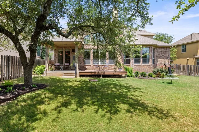 a front view of a house with a garden and trees