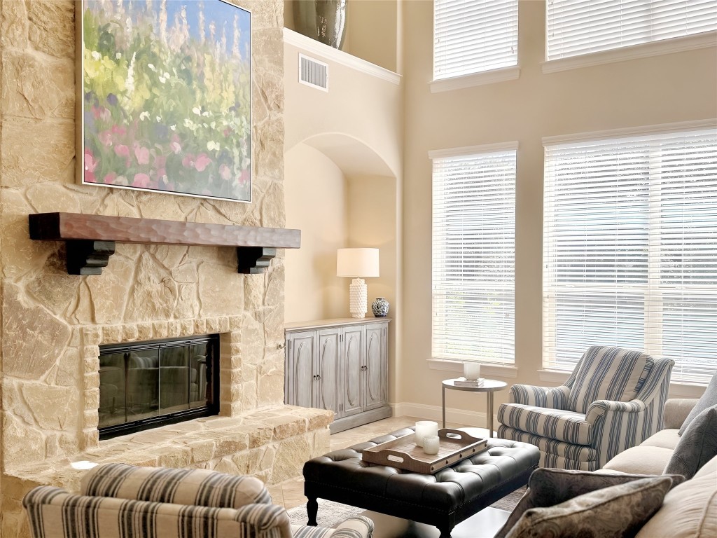 8709 Fescue Lane Austin, TX 78738 - Photo 2 of 36 a living room with furniture a fireplace and a table