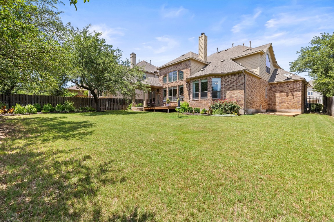 8709 Fescue Lane Austin, TX 78738 - Photo 29 of 36 a front view of a house with a garden and trees