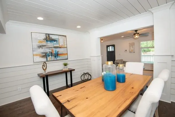 a view of a dining room with furniture a potted plant and wooden floor