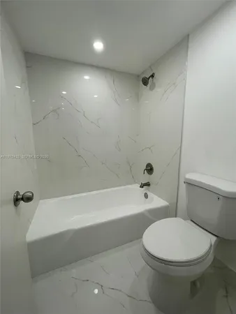 a bathroom with a toilet a sink and bathtub