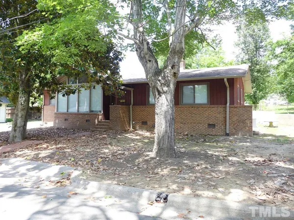a tree in front of a white house