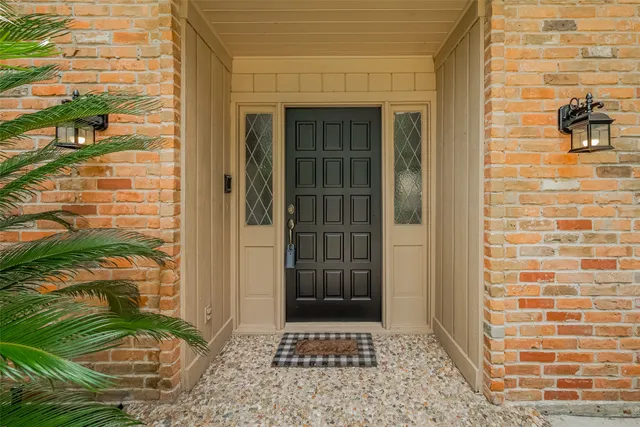 a view of a room with wooden floor a chandelier and windows