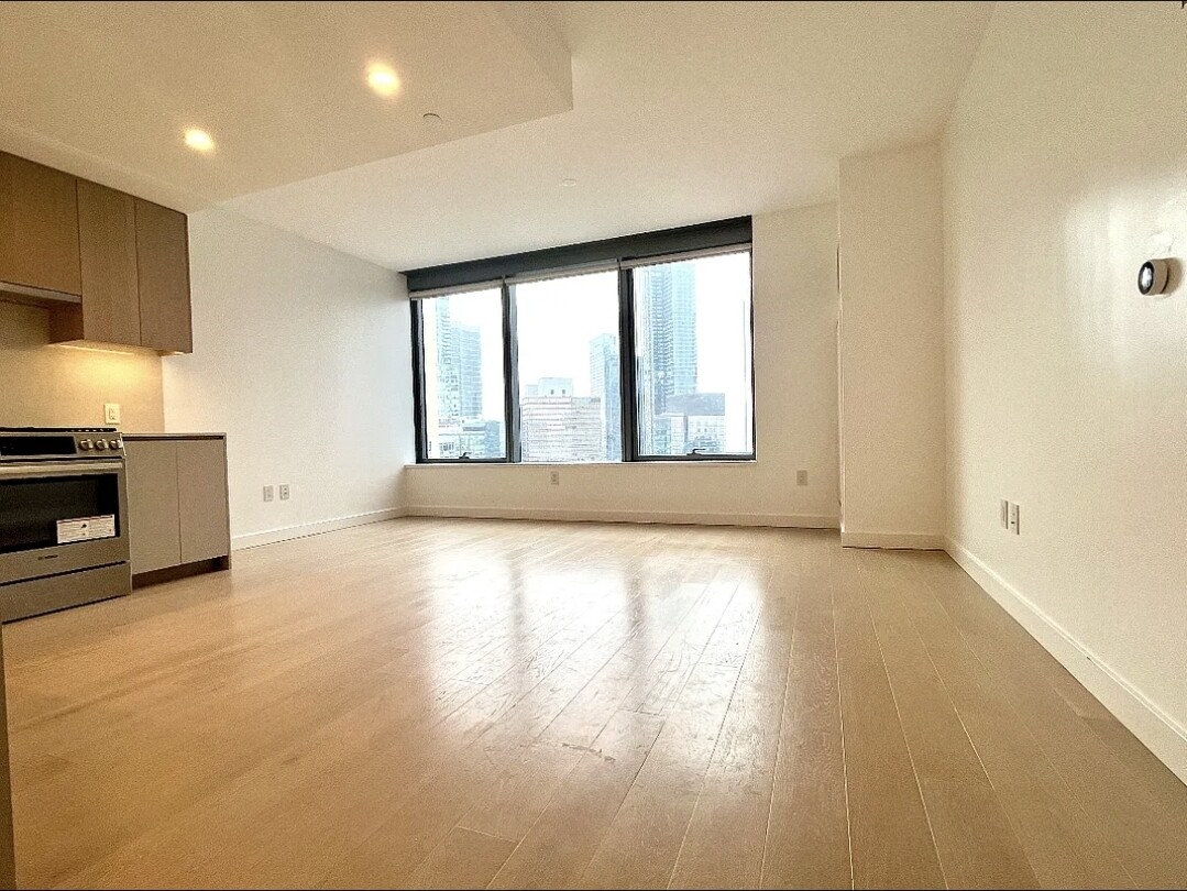 3 Court Square, Unit 2904 Queens, NY 11101 - Photo 2 of 12 a view of an empty room with a window and kitchen view
