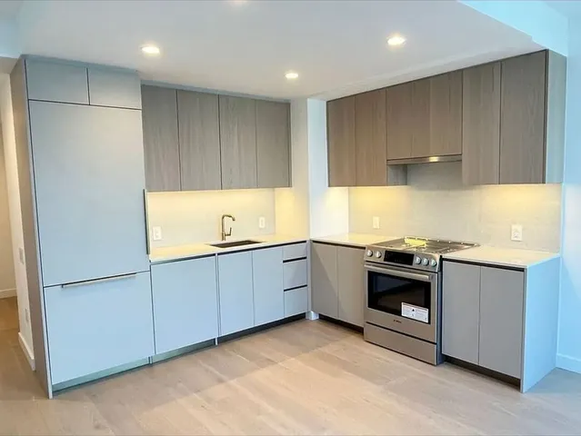 a kitchen with granite countertop a sink and a stove