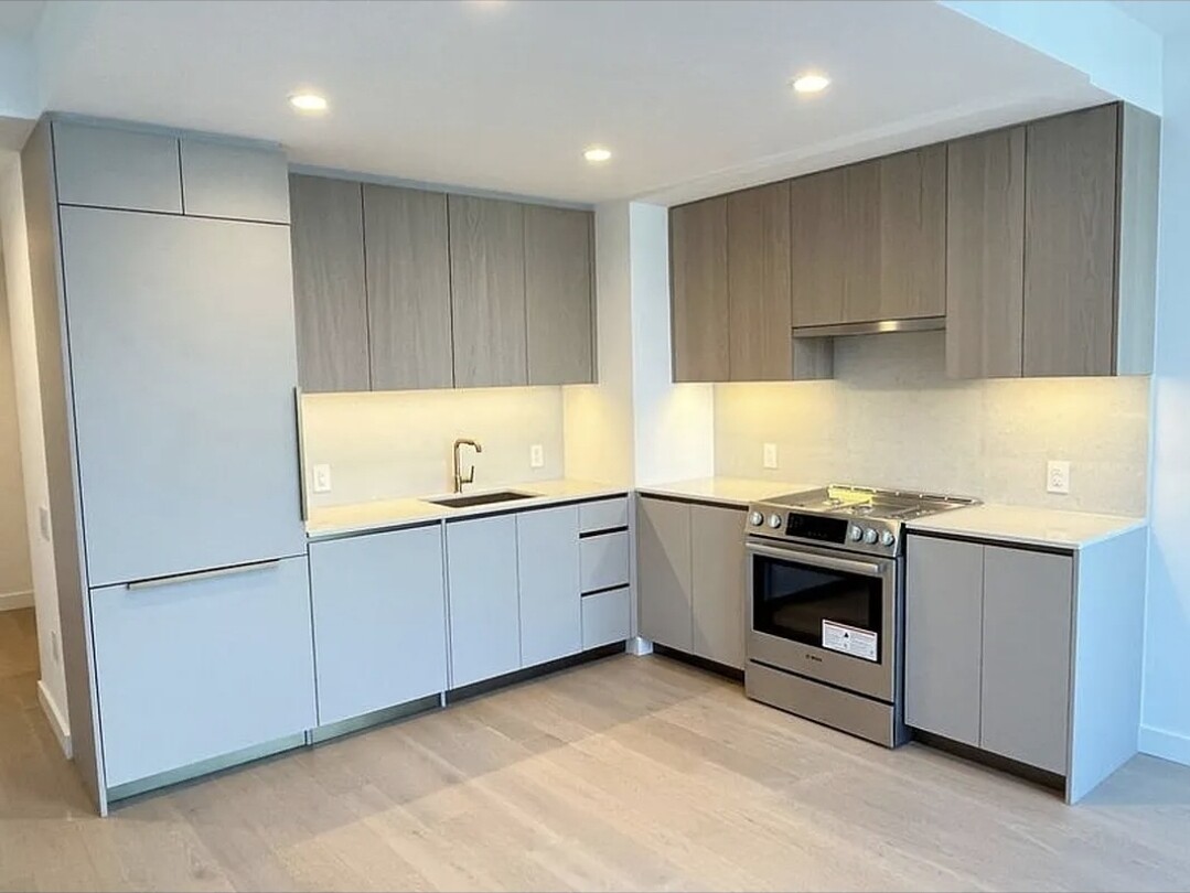 3 Court Square, Unit 2904 Queens, NY 11101 - Photo 3 of 12 a kitchen with granite countertop a sink and a stove