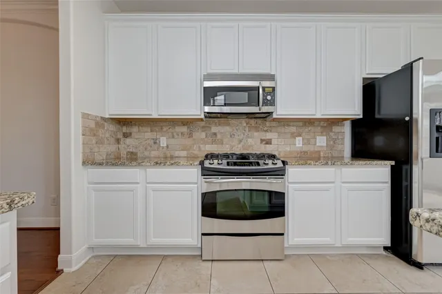 a kitchen with stainless steel appliances granite countertop white cabinets sink and stainless steel appliances