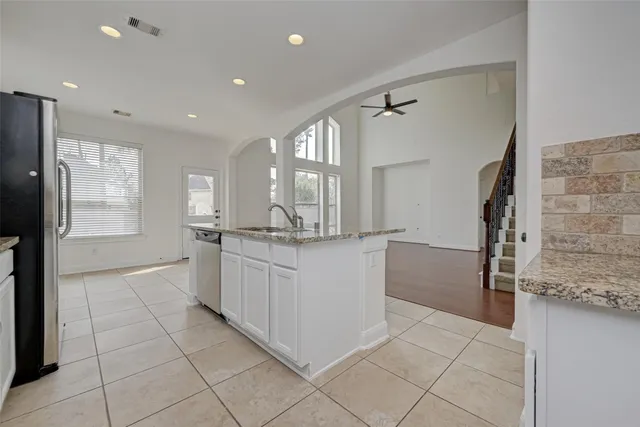 a large white kitchen with a sink and refrigerator